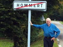 Paul Hommert next to a sign saying "Hommert" in the Alsace-Lorraine region of Eastern France